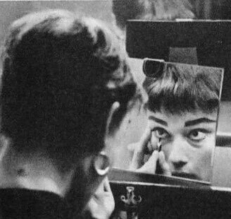 Audrey Hepburn applying makeup in her dressing room, 1954. 