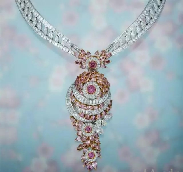 这款带玫瑰形吊坠的钻石项链以它大胆的设计和光彩夺目的钻石吸引住了参观者。这件首饰拥有总重22.90克拉的粉红色钻石，和总重48.99克拉的无色钻石，用18K白金和玫瑰金镶嵌。