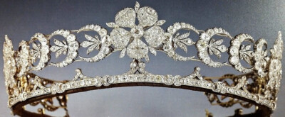 The Teck Crescent Tiara 这顶新月形钻石Tiara，最初的主人是玛丽王后的母亲泰克公爵夫人玛丽·阿德莱德公主，制成时间约为19世纪中晚期，它的材质包含了钻石、黄金和银。Tiara上所用到的钻石（包括上面的三朵钻石花…