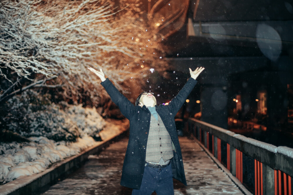 风雪夜归人
摄影：洪小漩
出镜：阿科
白天离开杭州时候，天是青灰色，无精打采的模样。
这一天，我们在绍兴忙着确定婚礼的场地。窗外雨雪交加，我们却顾不得抬头看一眼。
总算是张罗完了，长舒一口气。入夜，乘上回杭的高铁，彼时积雪已经有些模样。
阿科说想去看断桥残雪，我算了算时间不早，两人只得做罢。在家附近溜达一圈，散散步，拍拍照，也算是赏了雪景吧。
去年也遇到了一场雪景。我们从泰国旅行回来，飞机落地，走出航站楼。举目看见路灯下雪簌簌地下，美极了。
希望以后每场雪，身边都是你。
