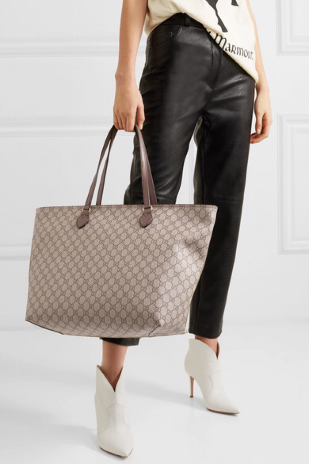 gucci 这款手提包以耐用的涂层帆布于意大利制成,包身印满该老牌时装