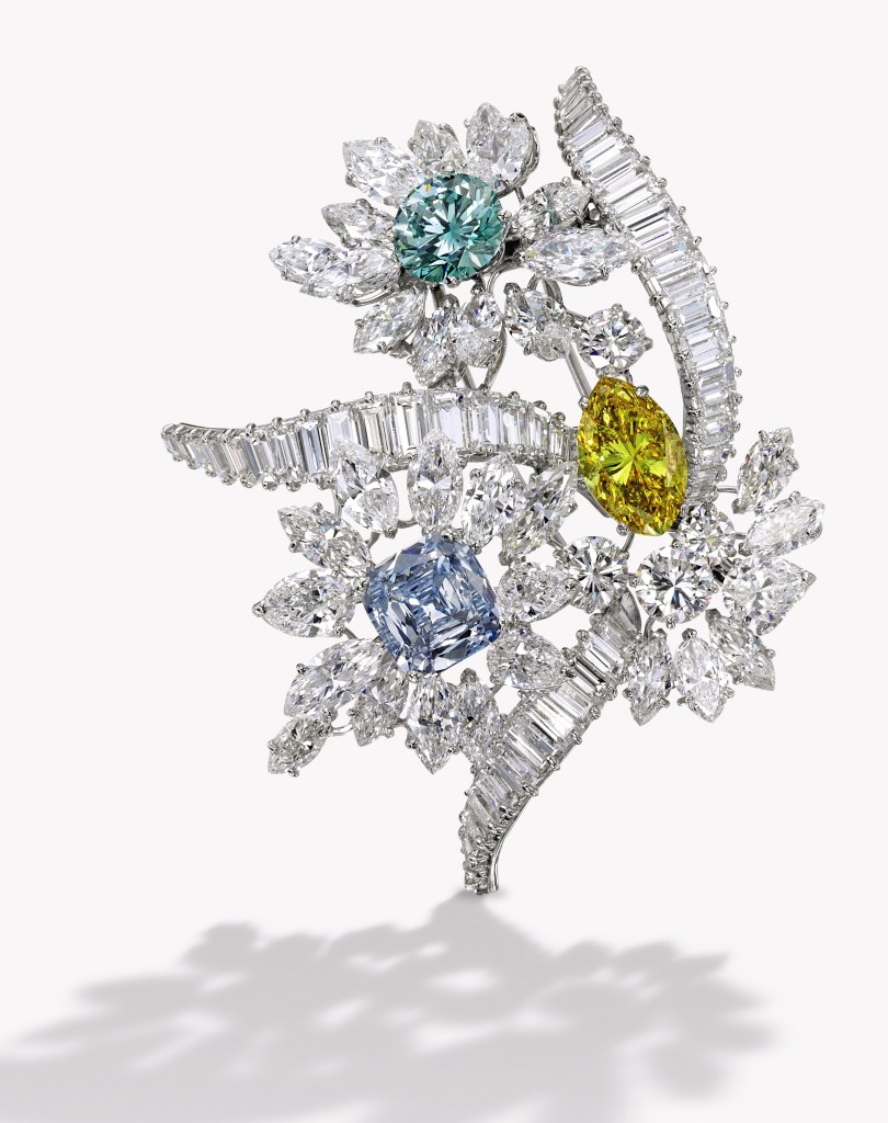 The fanciful floral bouquet set with a marquise-shaped Fancy Vivid Yellow, I1 clarity diamond weighing 2.86c, a round-cornered square modified brilliant-cut Fancy Intense Blue, VS2 clarity diamond weighing 2.47c and a round Fancy Intense Bluish Green, SI1 clarity diamond weighing 2.09c
