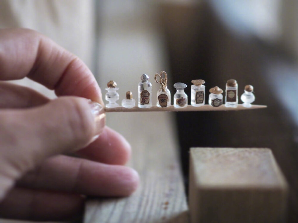 精心制作的微缩室内装饰元素日本微雕艺术家 Kiyomi 以惊人的专注细节模仿古董，创造出磨损和云雾状的玻璃罐子，略微失去光泽的银器，以及装满几十个抽屉的箱子。这位才华横溢的工匠用纸、金属丝、木头和其他模仿大娃娃的材料制作玩偶屋。
