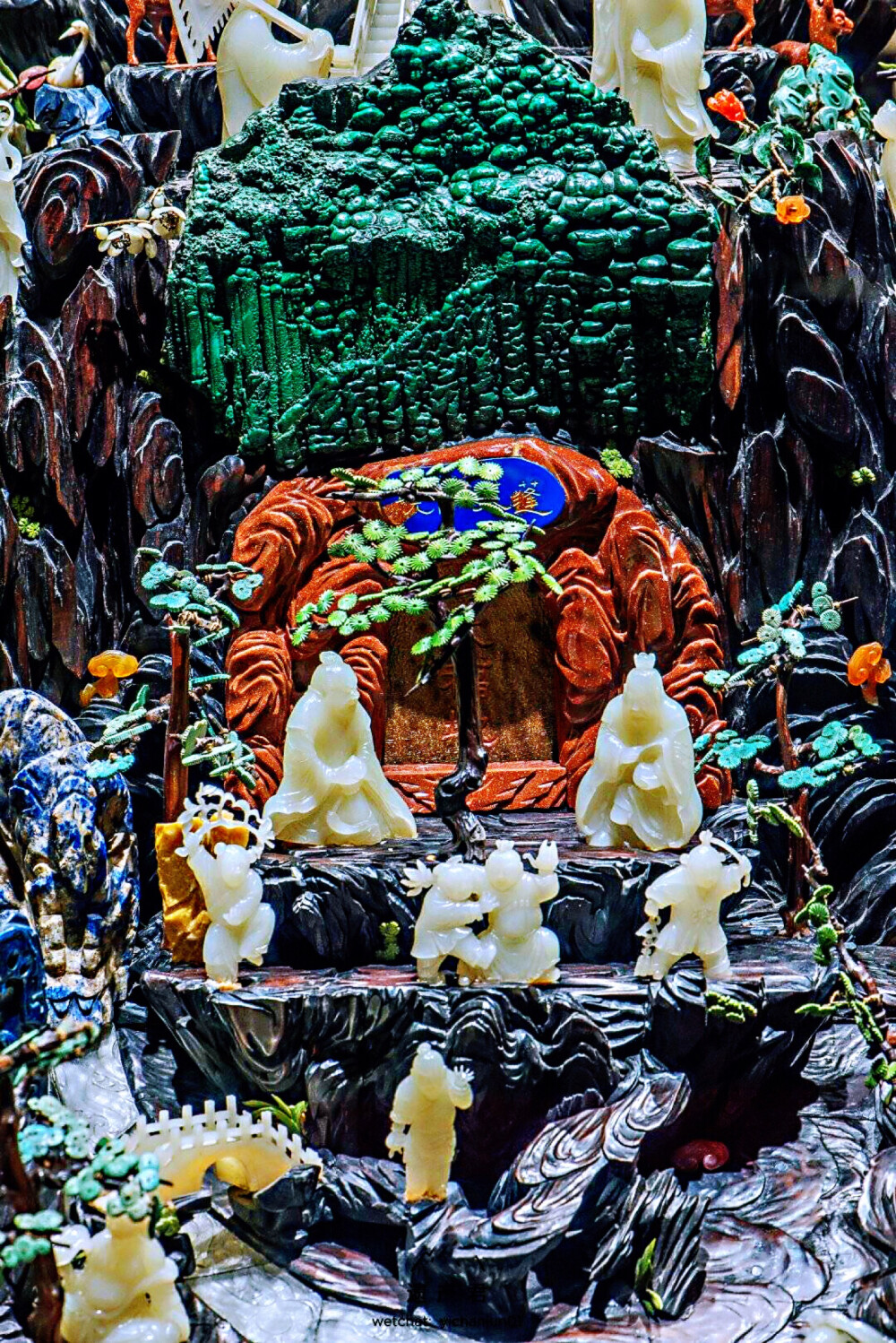 故宫博物院藏· 清代紫檀座玉石蓬莱仙境，此为慈禧六十寿辰时大臣恭进的寿礼，高130厘米，长117厘米，宽96厘米。匠师用玉石、金星石、绿松石、翡翠、玛瑙及各色晶石等贵重材料雕琢出白猿、老寿星、八仙、童子、梅花鹿以及翠柏灵芝、奇花异草，表现出仙境之神奇美妙。它以“群仙祝寿”为题材，用紫檀木雕成“蓬莱仙境”、“洞天福地”、“玉宇瑶池”三仙洞。