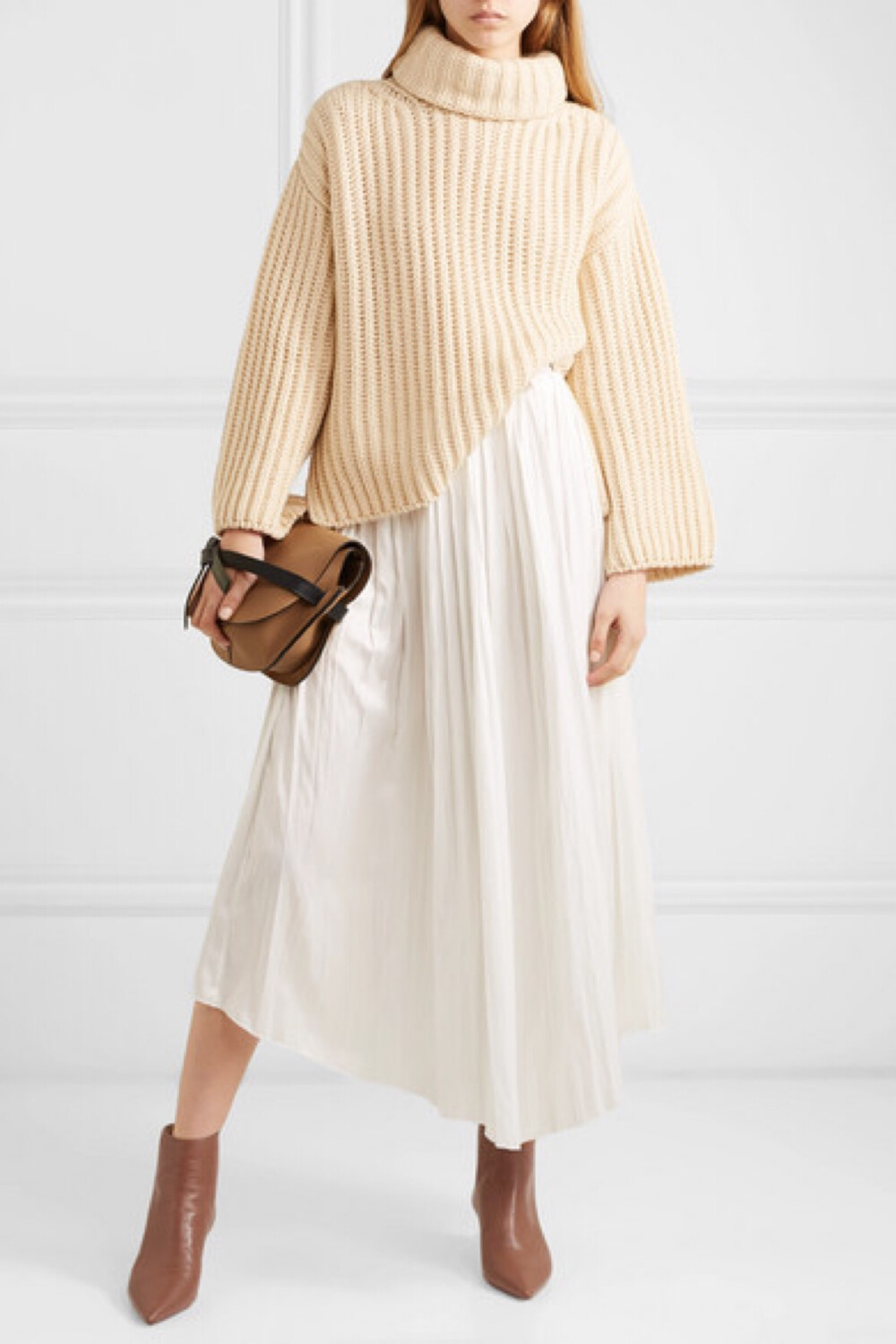 Alexandre Birman 认为款式经典、材质优良、造型趣致是评价鞋履的三大要素，这款 “Kittie” 尖头踝靴就符合上述优点，体现了设计师本人的创作理念。它采用无比柔软的茶色皮革打造，配有同色调拉链，坐于 5 厘米的小猫跟之上。经典百搭如它，平常适合与牛仔裤同穿，办公时换搭中性色长裤即可。