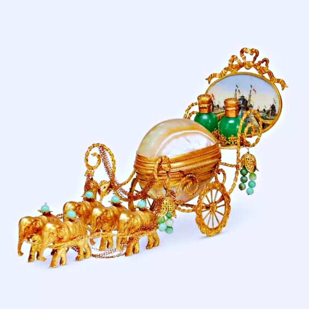 19世纪法国出品马车造型香水瓶，具有浓郁的东方风格。五头鎏金大象拉着母贝制成的蛋形车厢，两个绿色香水瓶放置在末端。