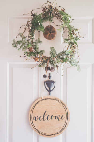 Photo of a White Door With a Hanging Wreath and Welcome Decor