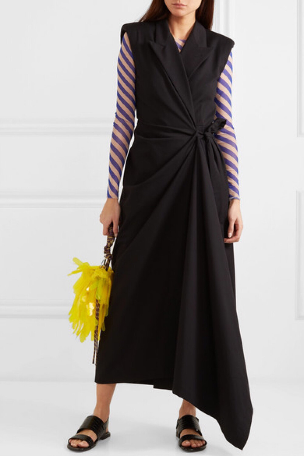 Dries Van Noten 在品牌 2019 春夏大秀的后台上说道，该系列作品带有高定服饰的特点，但却并不复古。这款连衣裙裁自棉质羊毛混纺斜纹布，垂感十足，腰间收束感的缩褶围裹式设计形成了优雅的不对称裙摆。垫肩和尖领则是承袭了精裁服饰的元素，十分经典。不妨配以同品牌令人玩味的 PVC 手提包。