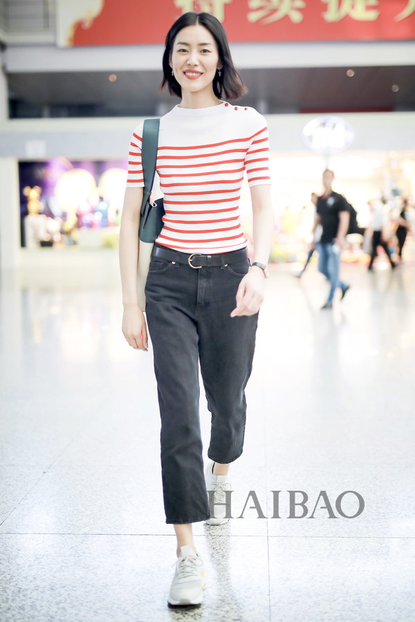刘雯2018年6月13日上海机场街拍：身着鄂尔多斯 (Erdos) 条纹针织衫，踩PUMA RS-0 Play系列运动鞋，肩背博柏利 (Burberry) 大号水桶包