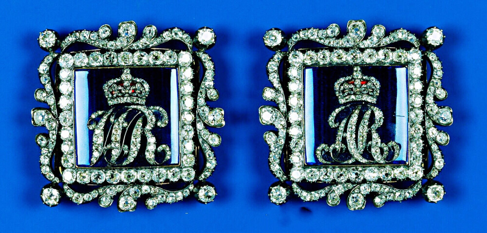 King William IV&Queen Adelaide Enamel Buckles 这两块方形蓝色珐琅扣最初属于威廉四世的妻子阿德莱德王后，被钻石设计包围着的蓝色珐琅扣中心分别用钻石镶嵌了代表他们夫妇二人名号的缩写“WR”和“AR”，1849年阿德莱德王后去世之后把它俩留给了妯娌剑桥公爵夫人奥古斯塔，1889年老公爵夫人去世后又把它们传给了小女儿泰克公爵夫人玛丽·阿德莱德，1897年再传到玛丽王后的手里。1953年玛格丽特公主在祖母去世后继承了它们，后来委托珠宝商给两块珐琅扣上分别加了七层珍珠链子，就这样完美变身成为手链。公主在上世纪50年代末至60年代初这段时间里戴过这手链挺多次的，2002年玛格丽特过世之后已经回归到王室收藏。