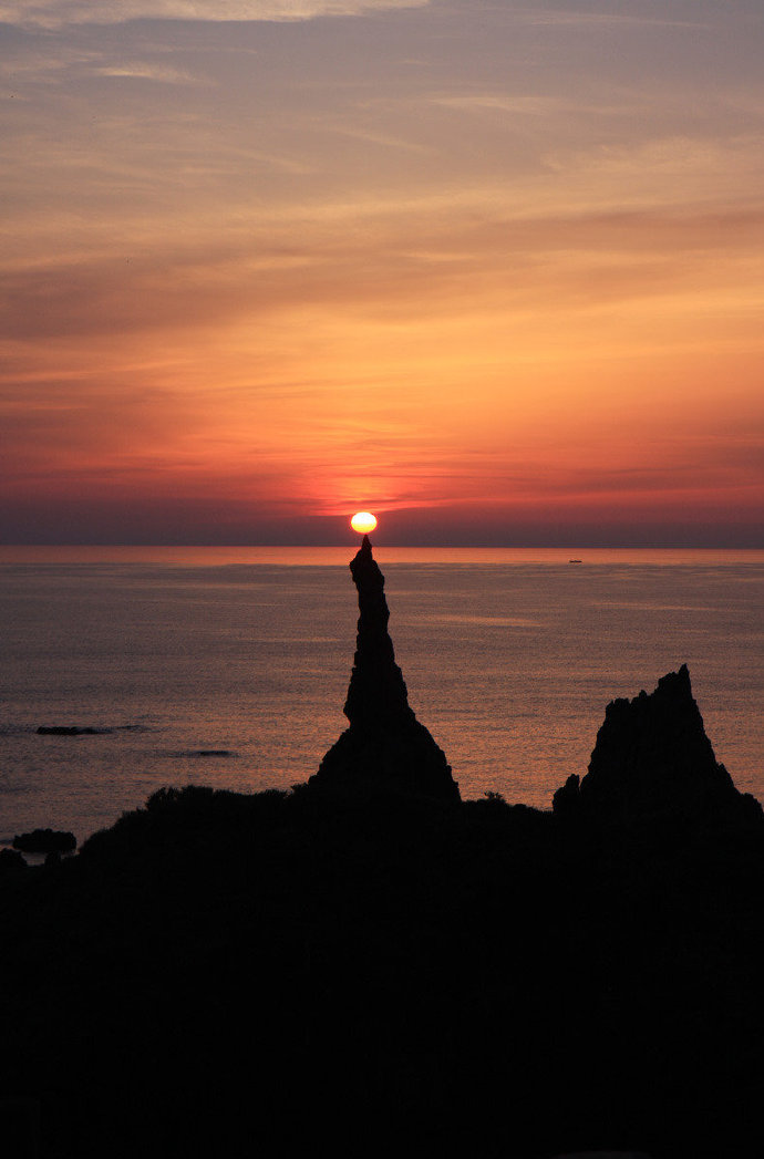 点燃的烛火，日本北海道积丹半岛的蜡烛岩与太阳一起呈现的奇观