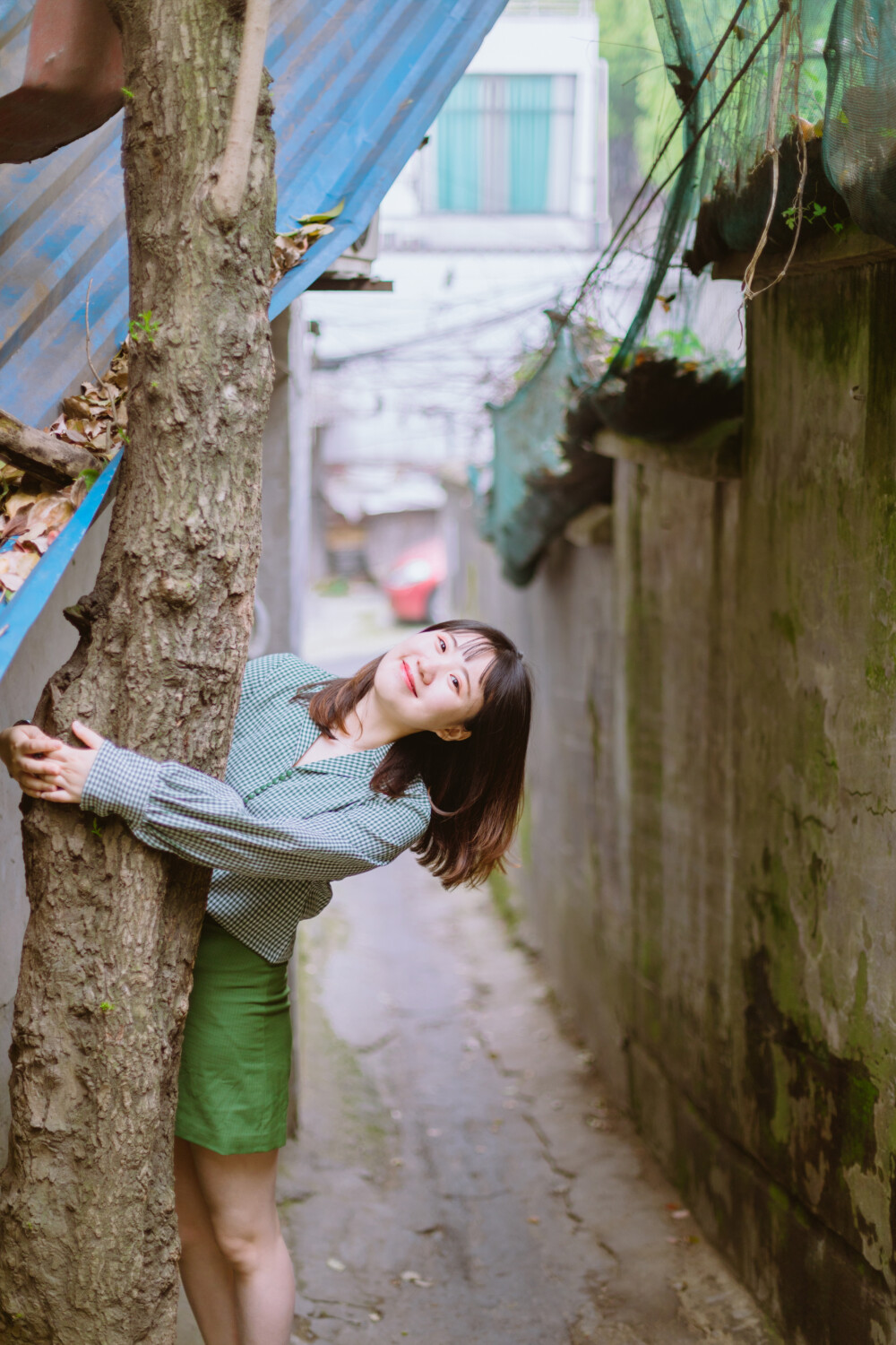 牛油果小姐
摄影：洪小漩
出镜：若男
场地：馒头山社区
馒头山社区在杭州摄影圈子里，那是有一定地位的。
在这里，有一颗杭州市斤的老灵魂。
在G20之前，馒头山社区应该还要多几分破败，不过，后来被修缮了一番。修缮后的模样，在我看来，仿佛是个老态龙钟的前辈，换了件相对体面的外套。
虽然我不知道社区居民对于修葺一新后的家如何思量，但是我依然喜欢走进些，再走进些，探访那些斑驳的民居，听听门前屋后的老杭州不紧不慢地聊着天。
若男那天穿得像一颗活泼的牛油果，素来极具亲和力的她瞬间和社区阿姨养的一条泰迪熟络起来。
泰迪叫贝贝，阿姨说，贝贝通体雪白，可是个白雪公主呢。只要有来着拍照的小年轻，大家总喜欢把贝贝逗上一逗。我们家贝贝呀可是馒头山的网红呢，是吧，阿姨把眼皮从手上忙活不停的针线活中抬了抬，看了看贝贝，如是说道。
生活在这里，应该也很有趣吧。