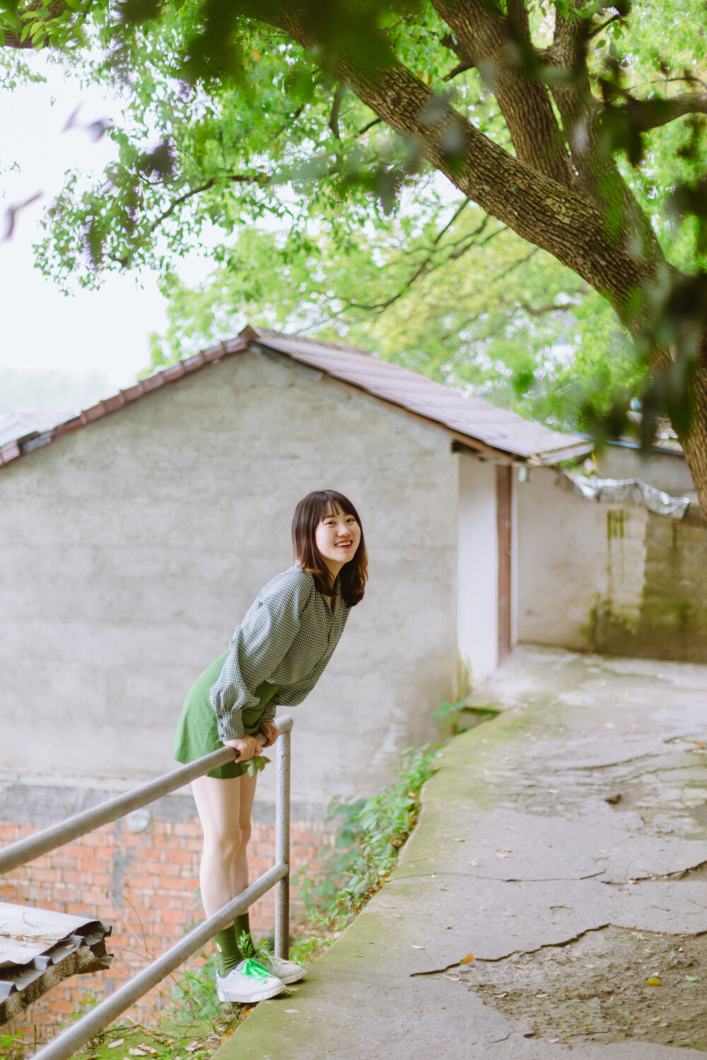 牛油果小姐
摄影：洪小漩
出镜：若男
场地：馒头山社区
馒头山社区在杭州摄影圈子里，那是有一定地位的。
在这里，有一颗杭州市斤的老灵魂。
在G20之前，馒头山社区应该还要多几分破败，不过，后来被修缮了一番。修缮后的模样，在我看来，仿佛是个老态龙钟的前辈，换了件相对体面的外套。
虽然我不知道社区居民对于修葺一新后的家如何思量，但是我依然喜欢走进些，再走进些，探访那些斑驳的民居，听听门前屋后的老杭州不紧不慢地聊着天。
若男那天穿得像一颗活泼的牛油果，素来极具亲和力的她瞬间和社区阿姨养的一条泰迪熟络起来。
泰迪叫贝贝，阿姨说，贝贝通体雪白，可是个白雪公主呢。只要有来着拍照的小年轻，大家总喜欢把贝贝逗上一逗。我们家贝贝呀可是馒头山的网红呢，是吧，阿姨把眼皮从手上忙活不停的针线活中抬了抬，看了看贝贝，如是说道。
生活在这里，应该也很有趣吧。