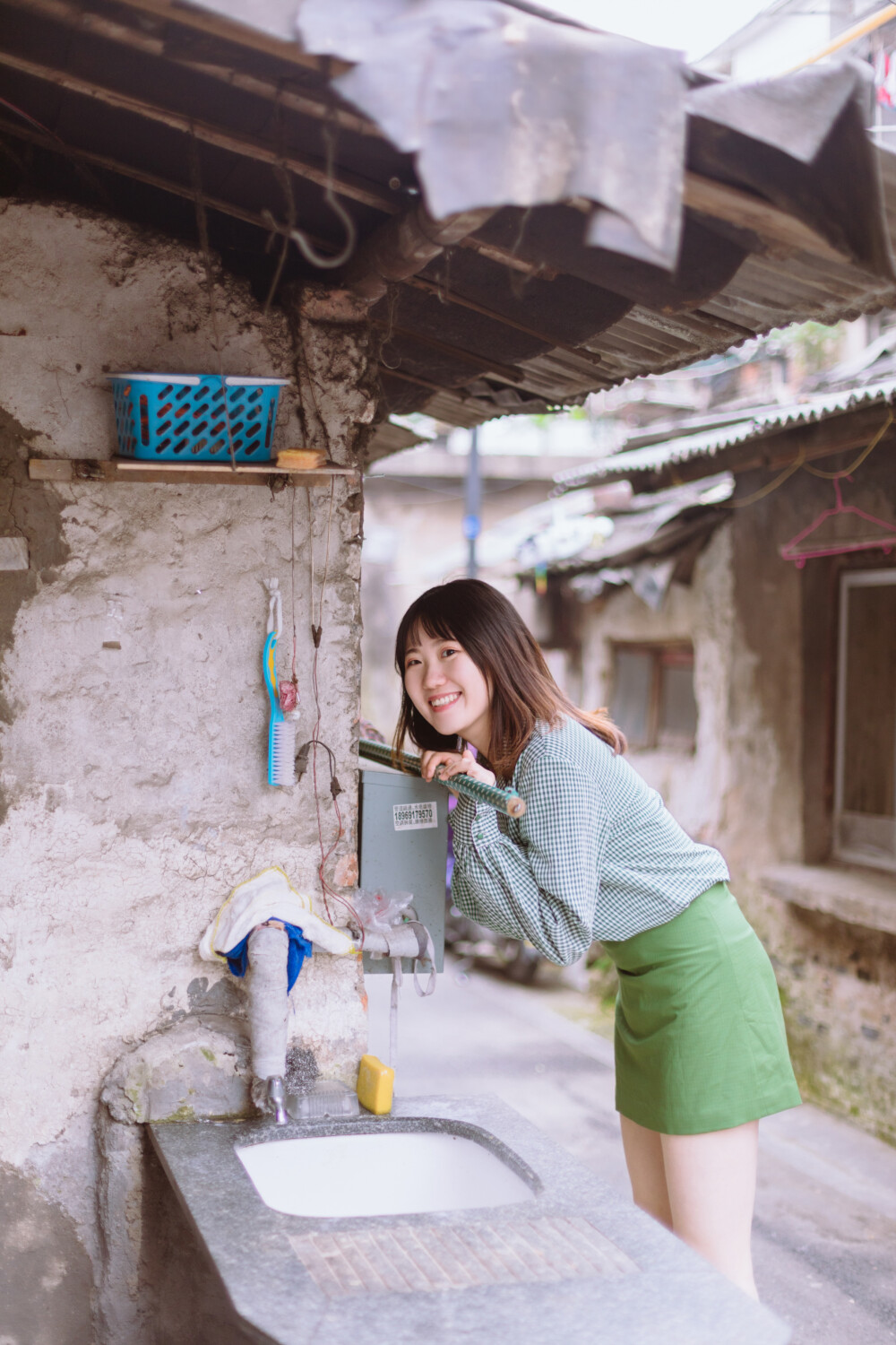 牛油果小姐
摄影：洪小漩
出镜：若男
场地：馒头山社区
馒头山社区在杭州摄影圈子里，那是有一定地位的。
在这里，有一颗杭州市斤的老灵魂。
在G20之前，馒头山社区应该还要多几分破败，不过，后来被修缮了一番。修缮后的模样，在我看来，仿佛是个老态龙钟的前辈，换了件相对体面的外套。
虽然我不知道社区居民对于修葺一新后的家如何思量，但是我依然喜欢走进些，再走进些，探访那些斑驳的民居，听听门前屋后的老杭州不紧不慢地聊着天。
若男那天穿得像一颗活泼的牛油果，素来极具亲和力的她瞬间和社区阿姨养的一条泰迪熟络起来。
泰迪叫贝贝，阿姨说，贝贝通体雪白，可是个白雪公主呢。只要有来着拍照的小年轻，大家总喜欢把贝贝逗上一逗。我们家贝贝呀可是馒头山的网红呢，是吧，阿姨把眼皮从手上忙活不停的针线活中抬了抬，看了看贝贝，如是说道。
生活在这里，应该也很有趣吧。