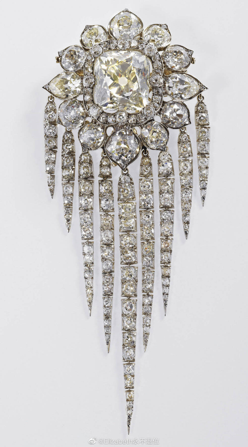 Queen Victoria's Fringe Brooch 这枚精美华丽的钻石胸针是维多利亚女王委托加纳德珠宝于1856年制作完成的，12.6×5cm，所用材质包括了钻石、黄金和银。胸针的中央镶嵌了一颗硕大的祖母绿型切割钻石（当年早些时候土耳其苏丹送给维多利亚女王的礼物），是可以取下单独当胸针佩戴的，它的四周被12颗明亮型切割钻石所包围，底部还坠有9条钻石流苏，是可以自由拆卸下来的。在一个多世纪的岁月里，维多利亚女王、亚历山德拉王后、玛丽王后、伊丽莎白王后、伊丽莎白二世女王五代女性都佩戴过它，这其中伊丽莎白王后是佩戴出镜最多的，是她的真爱胸针之一。2002年女王在母亲去世之后继承，到目前为止一共才戴过两次，依旧希望今后能多多出镜吧~