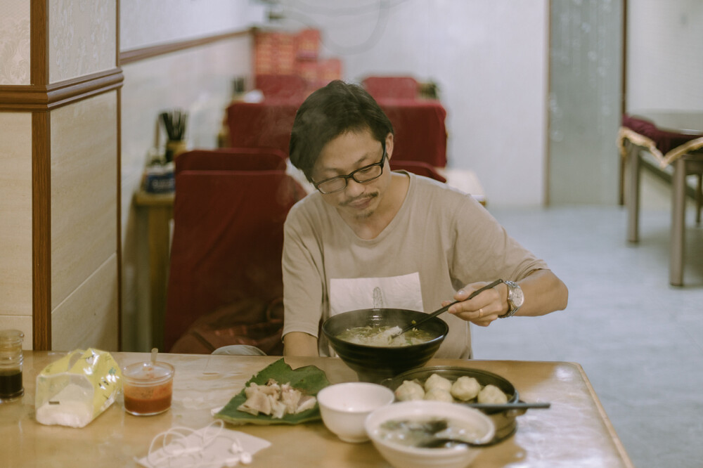 杨梅熟了
摄影：洪小漩
出镜：家人
梅雨时节，家中爷爷种的杨梅也到了时候。阿科心心念念，说要买个酒缸，回家为妈妈浸一些杨梅酒。
回去之前，阿科和小叔打了个电话，小叔不知道从哪里搞来一辆三轮车，在集市上买了些浸酒的糟烧，捎上我们俩，一同去爷爷奶奶家。
并排席地坐在小叔驾驶的“敞篷车”上，看着两边风景后退，那感觉还蛮妙的。
和以往的每次一样，爷爷奶奶早已准备好了一桌饭菜，其中，绍兴梅干菜扣肉是从未缺过席的。五个人围着八仙桌入座，除了我外，几乎每个人在吃饭之前，都要喝点小酒，小叔斟的是黄酒，爷爷奶奶是杨梅烧，阿科则随性作陪，象征性喝几口便满脸涨红。
来了那么多次，爷爷奶奶依然用不太标准的普通话一直招呼我，吃肉，多吃点，再吃点。小叔担心我故作客气，便主动帮我开了第二瓶六个核桃。这倒是搞得我有些不好意思。
饭罢，几个人换了长袖长裤套鞋，提着锄头柴刀框子上山摘杨梅。爷爷的杨梅种在半山腰，年岁比阿科的小不了太多。看着满地跌落的杨梅，阿科说，爷爷这些年体力不济了，以往都是他老人家独自上树采好，等着孩子们回家来。
杨梅树枝脆得很，攀爬采摘，稍有不慎，可能就会折断。小叔择一些偏细的枝丫用