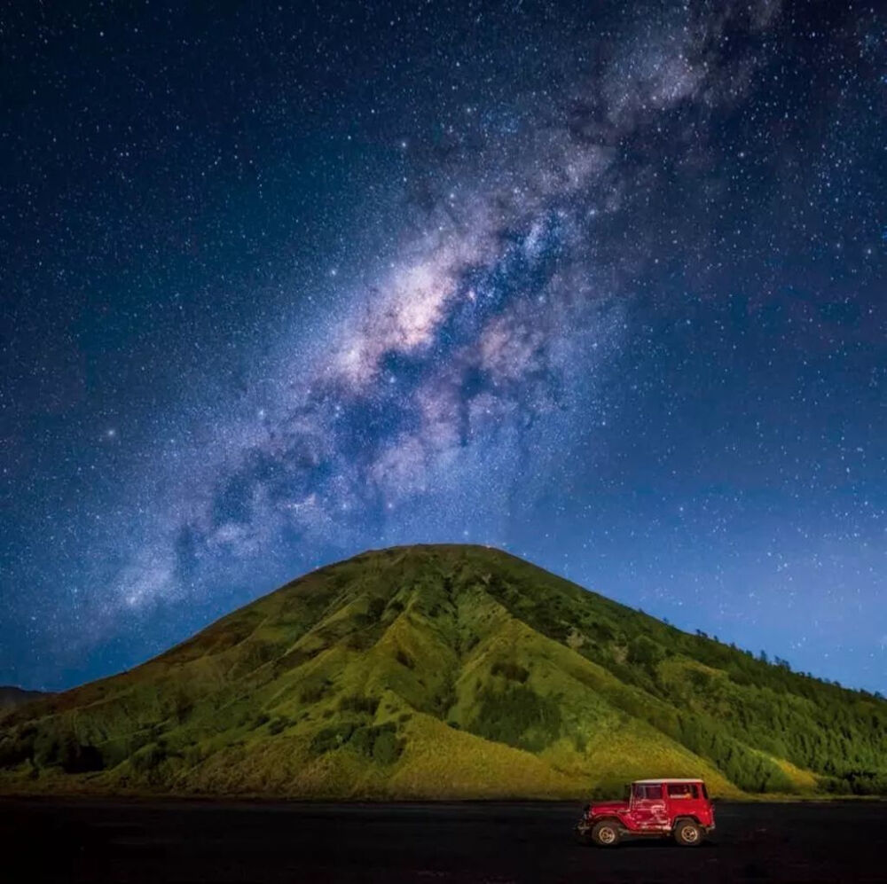 印度尼西亚，爪哇岛。婆罗摩火山上方星河的光束垂散下来。 摄影：韦莱卡姆·萨缇缇尼莱迈（Weerakarn Satitniramai）