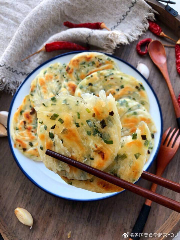 ㊙️超好吃的面食之～饺子皮版手撕葱油饼（附详细做法）应该有不少小伙伴超级爱吃面食，但又不喜欢揉面甚至不会......来、来、来！今天跟着一起做饺子皮版的手撕葱油饼吧！特别好吃制作过程也是更简单了，手撕着吃感觉超棒，三个字：超好吃！喜欢吃的小伙伴们赶紧行动起来吧！墙裂推荐！做法如下食材清单：葱适量，饺皮18个（饺皮买的）1⃣️：先调葱馅：葱切小段➕少许盐➕半汤匙食用油➕少许黑胡椒，搅拌均匀葱馅就完成了！2⃣️：三个饺皮（三个饺皮一组做一个葱油饼）如图两个饺皮调上馅料，依次放一起按扁擀成椭圆形3⃣️用刀在上如图横着划几刀，从一边卷起然后如图旋转几次，一端压下面绕圆圈另一端也压在葱油坯下面按