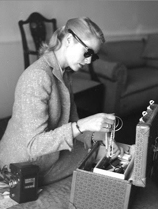 Grace Kelly, in Cannes for the Film Festival, putting away her jewelry at the Carlton Hotel, 1955