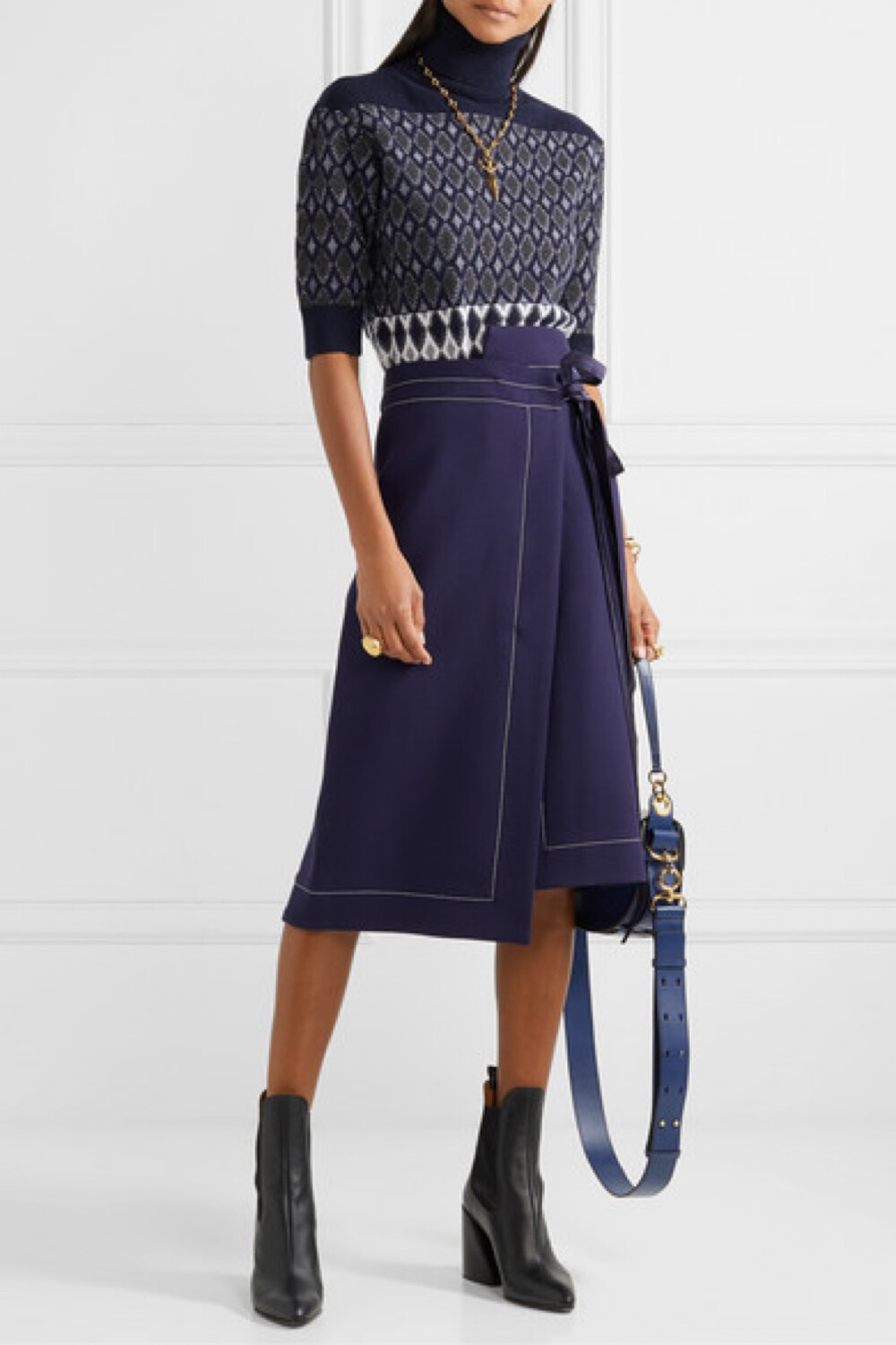 出席 Chloé 2019 巴黎秋冬时装秀的嘉宾均收到了一张放置于座位上的明信片，上面表达了品牌对已故传奇设计师 Karl Lagerfeld 的满满敬意——他曾于 70 和 90 年代，为此时装屋献力创作。这款短袖毛衣出自本季系列，采用美利奴羊毛混纺面料制成，其上织有精美的菱形图样，还配有罗纹高领为你御寒保暖。何不偷师秀场造型，将单品叠搭于顺滑的衬衫之上？