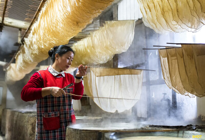 豆腐皮
在浙江省宁波市的一家商店里，一名妇女在用传统技术制作豆腐皮。“在煮豆浆的过程中，在浅口平底锅里，液体表面会形成一层膜或者说一层漪，”摄影师James Yang解说道，“把这些膜收集起来，晾干成淡黄色…