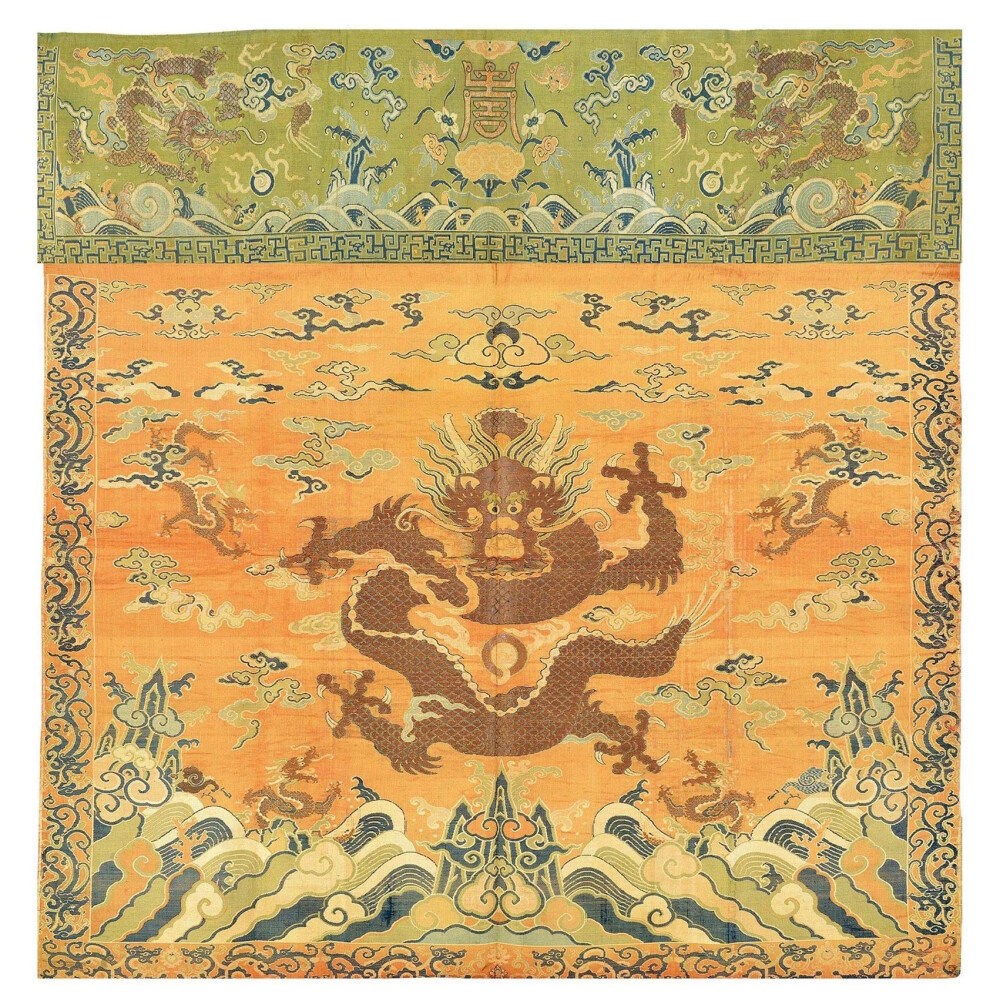 【杏黄色云蟒纹妆花缎桌帷】——清乾隆，尺寸：100cm×26cm；84.5cm×83cm。本品为一组桌帷。杏黄色底面正中妆花织满天祥云，正中四爪金蟒一条，其下为海水江崖纹，蟒身四周亦有四条较小金蟒从云中与海面探身而出，遥相呼应。上沿绿色底面妆花织就海水江崖纹，海面正中灵芝托起金色寿字，四周环以祥云与蝙蝠，又有二龙出海，穿云越雾。织工严谨，晕色自然和谐。