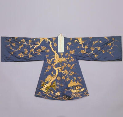 【蓝色缎平金绣整枝松鹤石纹老旦帔】——清乾隆，故宫博物院藏。戏衣，帔在蓝色缎地上用双圆金线和孔雀羽线绣松鹤纹。前后身各绣一棵松树，树上栖有仙鹤，树下湖石旁有兰花、月季、丛竹等纹饰。鹤颈及湖石平台均以孔…