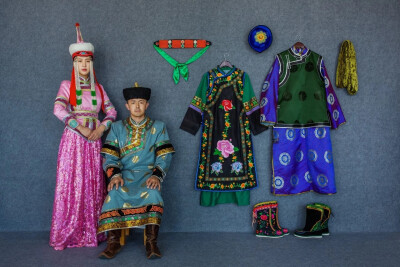 蒙古族服饰有鲜明的草原特点。无论男女，喜穿长袍，腰扎长绸带。蒙古袍肥大耐磨，骑马时可以护膝，睡觉时可以当被子。靴子、头饰、帽子和身上的配饰，颜色五彩缤纷。图中右侧挂着的是乃蛮部服饰，左侧青年男的叫宝才…