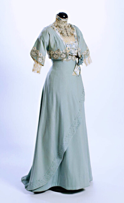 这件十分清雅的衣服是1911年一位新娘在婚礼后去剧院穿的，浅蓝灰色长裙，裙摆上有简单的同色花边，上身装点着轻巧的白蕾丝和少许印花缎子，有种很宜人的气质。 ​​​