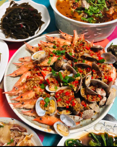 【蒜蓉粉丝蒸双鲜（蒜蓉粉丝蒸花甲虾）】
“蒸过之后花甲开口了，虾背也展开了，再淋酱料，淋的时候沿着盘边由四周向盘子中心均匀划圈，这样所有的地方基本都能淋到啦。清蒸的虾和花甲原汁原味，是非常健康的美味哦…