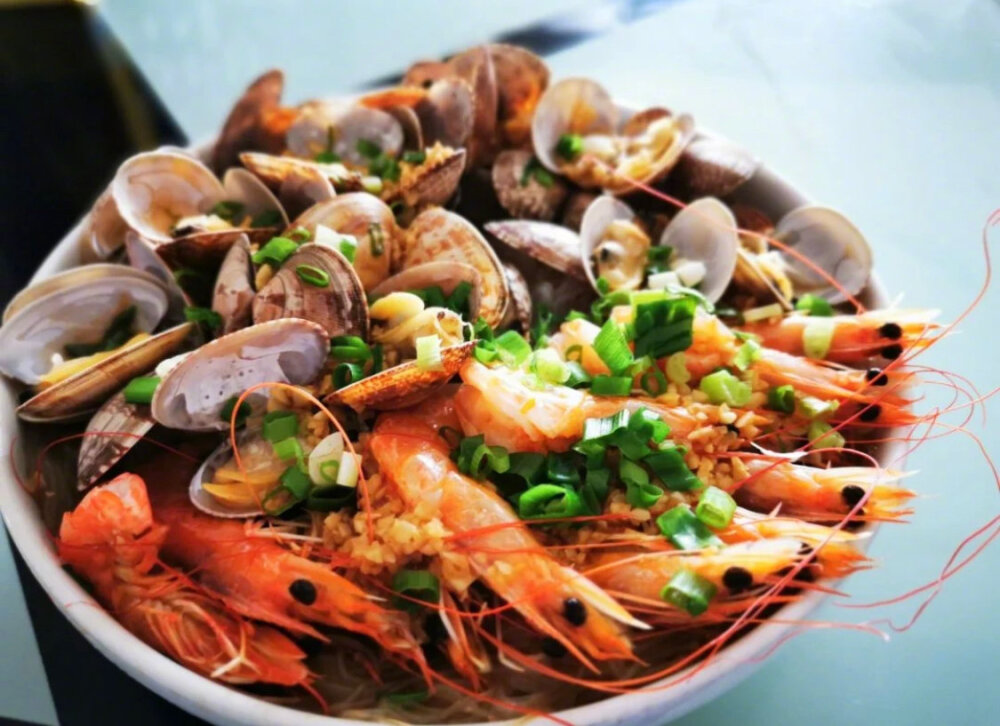 【蒜蓉粉丝蒸双鲜（蒜蓉粉丝蒸花甲虾）】
“蒸过之后花甲开口了，虾背也展开了，再淋酱料，淋的时候沿着盘边由四周向盘子中心均匀划圈，这样所有的地方基本都能淋到啦。清蒸的虾和花甲原汁原味，是非常健康的美味哦。家常、宴客都拿的出手哦，颜值爆表，又好看又好吃”
菜谱作者：prettytree美树