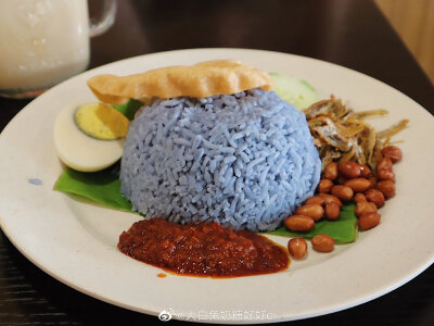 #槟城美食# 「小江豆浆」
乔治艺术街旁边的一家超红豆浆店，豆浆入口浓郁顺滑，同时也要点一份咖喱椰浆饭！
-椰浆饭 蓝色蝶豆花染成的饭 浇上满满一大碗咖喱和椰浆 鸡肉特别嫩 浓郁的椰奶咖喱香 拌着一大碗饭 吃起…