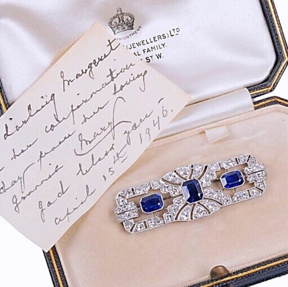 Princess Margaret's Art Deco Sapphire and Diamond Brooch 这枚具有装饰艺术风格的蓝宝石配钻石胸针，是玛格丽特公主在1946年4月15日举行坚信礼的时候祖母玛丽王后送给她的礼物。胸针大约制造于1925年，出自珠宝商Collingwood，镂空的几何形饰板镶嵌有三个矩形蓝宝石，与单个和旧切割的钻石边框相交融，4.5cm。装胸针的盒子里还附有一张玛丽王后写给孙女的字条：“在她坚信礼这天送给亲爱的玛格丽特，来自于她亲爱的奶奶玛丽，愿上帝保佑你，1946年4月15日。”不过这枚胸针玛格丽特只在早年戴过几次，后面就不见出现了，她去世之后胸针于2006年在佳士得拍卖行拍卖，当时的预估价是1500～2000英镑，最后成交价是66,000英镑。