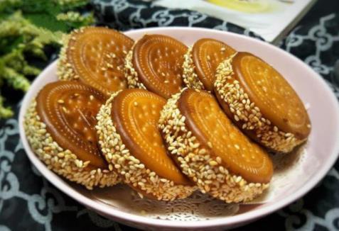 红薯饼红薯和饼干的完美结合，外酥里糯，特别的香甜，可以做早餐，也可以当零食吃~食材：红薯1个、芝麻适量、糯米粉1勺、白糖1勺1.红薯去皮切成薄片2.冷水上锅蒸10几分钟分钟，蒸熟3.蒸好的红薯放入干净的容器里，加入1勺糯米粉，1勺白糖，用勺子压碎捣成泥4.取一片饼干，上面抹上适量的红薯泥抹平5.然后上面再盖上一片饼干挤压一下，用勺子把周围挤出的红薯泥刮平6.一圈粘上芝麻7.油烧热后，放红薯饼入油锅，小火将红薯炸至两金黄8.捞出控油装盘