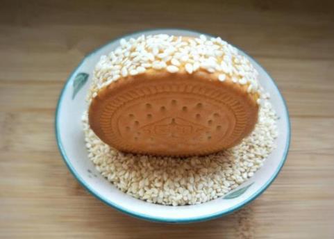 红薯饼红薯和饼干的完美结合，外酥里糯，特别的香甜，可以做早餐，也可以当零食吃~食材：红薯1个、芝麻适量、糯米粉1勺、白糖1勺1.红薯去皮切成薄片2.冷水上锅蒸10几分钟分钟，蒸熟3.蒸好的红薯放入干净的容器里，加入1勺糯米粉，1勺白糖，用勺子压碎捣成泥4.取一片饼干，上面抹上适量的红薯泥抹平5.然后上面再盖上一片饼干挤压一下，用勺子把周围挤出的红薯泥刮平6.一圈粘上芝麻7.油烧热后，放红薯饼入油锅，小火将红薯炸至两金黄8.捞出控油装盘