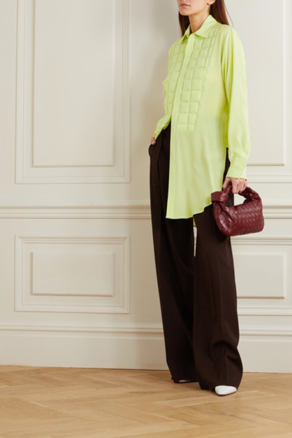 
Bottega Veneta 创意总监 Daniel Lee 重塑品牌标志性的 Intrecciato 编织工艺，推出的新季系列囊括了不少人气单品。其中这款柠檬绿色双绉女衫，采用宽松的长款设计，还在过肩处以绗缝手法呈现出颇具辨识度的皮革条编织纹理，令人不禁想起该时装屋大热的包款和鞋履。