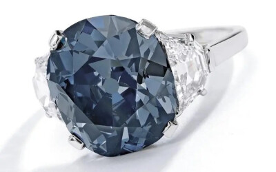 款4 7.55ct The Indian Blue蓝钻 三石戒指
The Indian Blue是一颗 Type IIa 型蓝钻，达到 Fancy Deep Grayish Blue色级和 SI2 净度级别，重7.55ct，枕形切割。这颗蓝钻镶嵌于一枚铂金戒指上，也是一枚三石款， 在主…