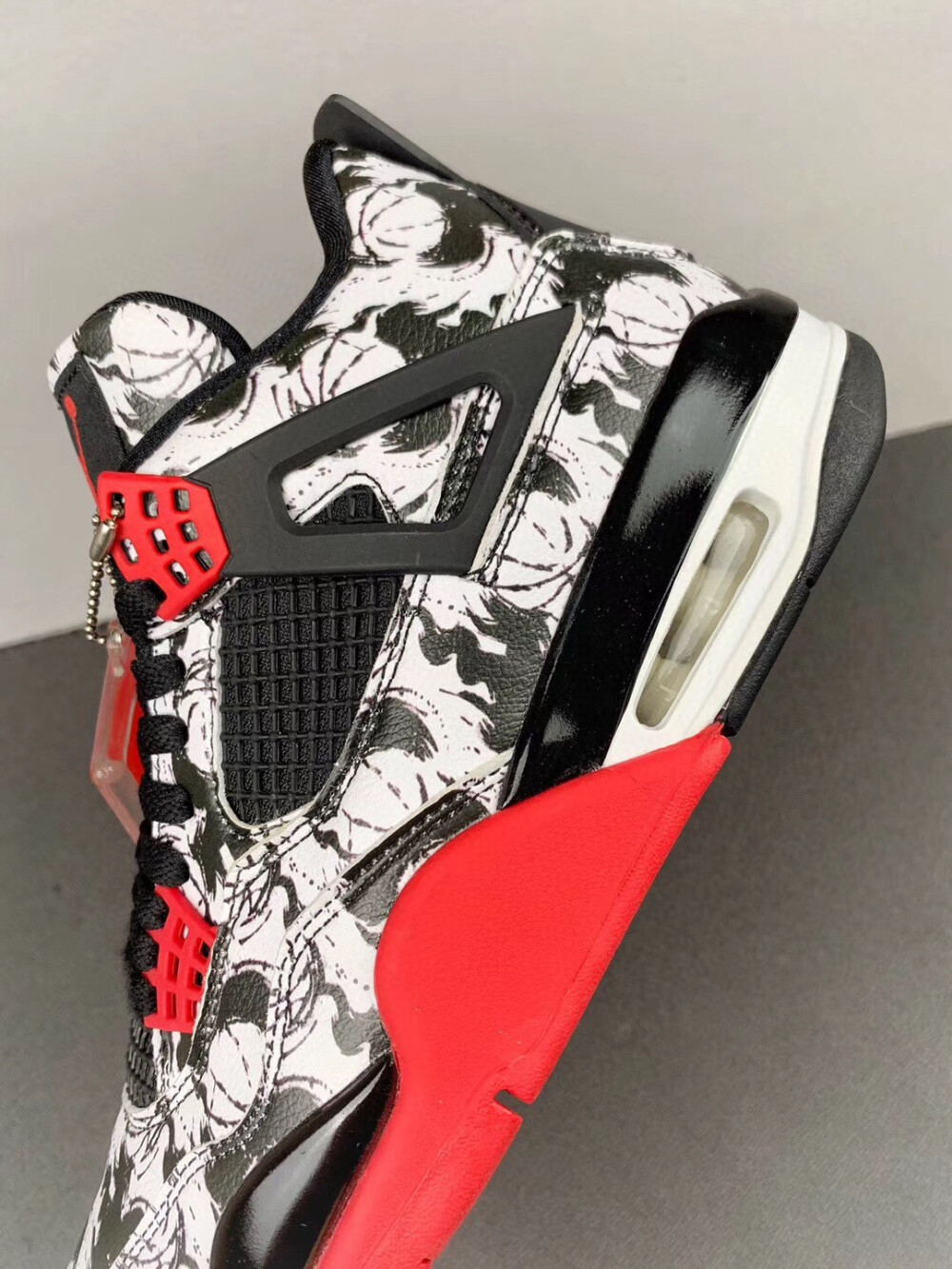 这双 Air Jordan 4 “Tattoo” 的设计团队 400ML，是目前国内很有影响力的涂鸦机构。所以这双Air Jordan 4也是很有涂鸦风格。鞋面是涂鸦风格，鞋底是红色、白色、黑色。整体的氛围是大气沉稳而又兼带这活力和辨识度。