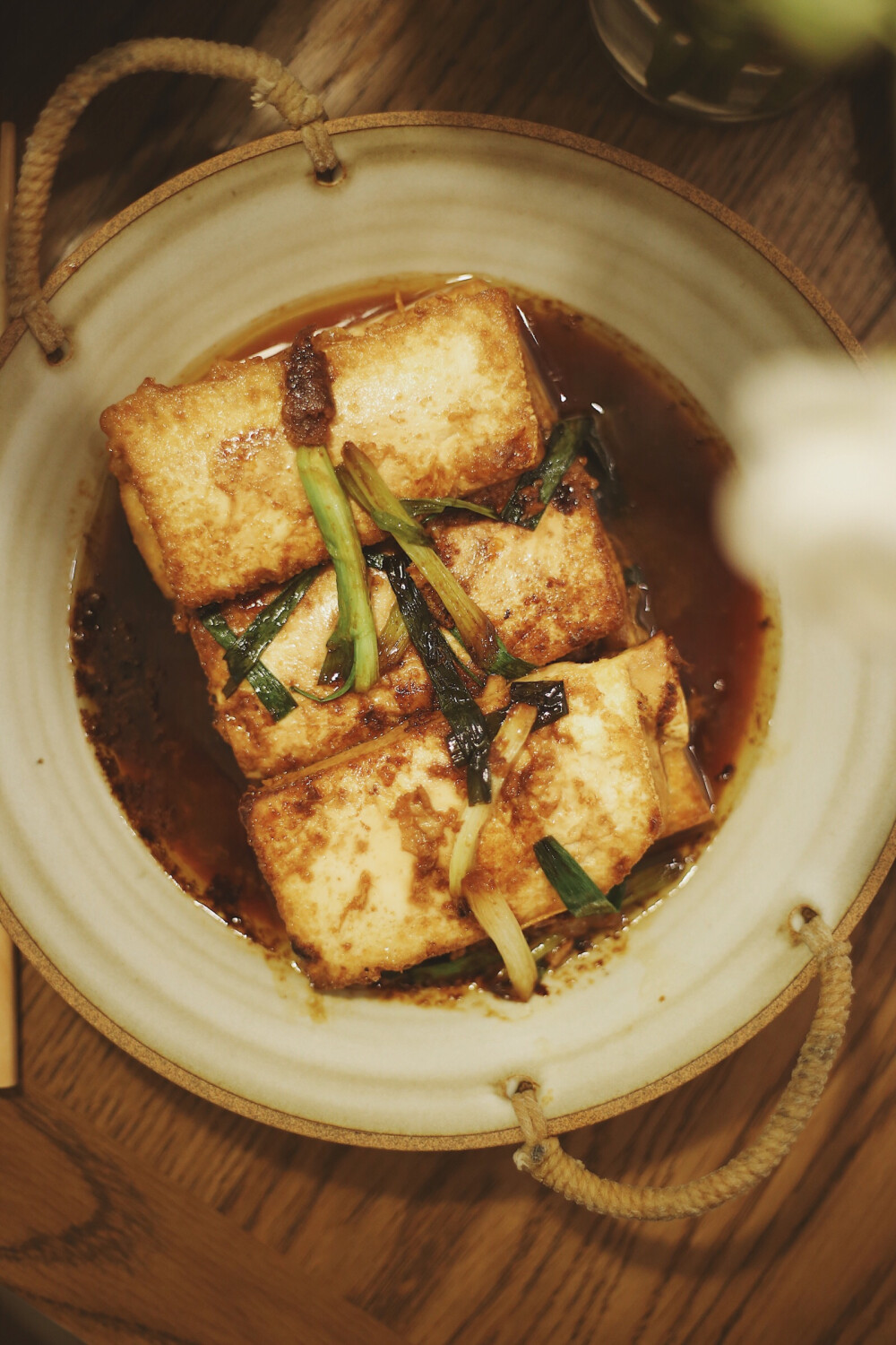 虾仁煨豆腐，两分钟出锅的好味快手家常。
食材：嫩豆腐一块，鲜虾几只。
做法很简单：嫩豆腐泡过盐水，稍稍去除豆腥味。对切再等分为三片。
1、平底锅内加入底油，轻轻取豆腐块蘸上鸡蛋液入锅煎
（tips：害怕溅油的话，入锅的时候可以关小火，之后再转大火）
2、大约一分钟，表面成型后翻面，同时加入虾仁。
3、准备调汁，老酒3汤匙，生抽1汤匙，白糖少许，口重的话可以再加少许盐。
4、出锅前撒一点葱段即成
快手、下饭、营养丰富，趁着周末在家试试哟！