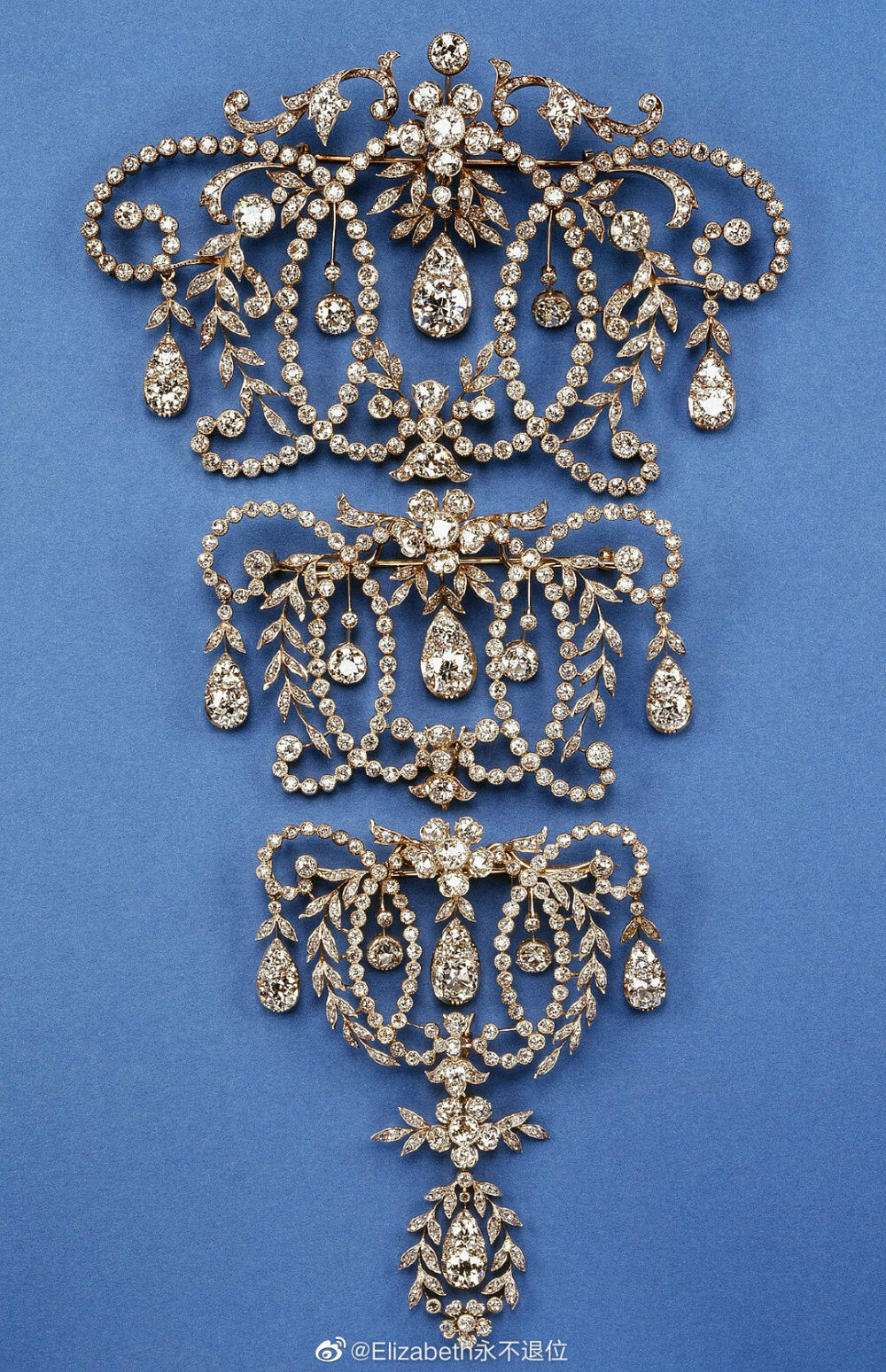 Queen Mary's Diamond Stomacher 这坨钻石Stomacher是由三个独立的钻石胸针组合而来的，可以全部佩戴也可以单独拆下来戴，整体22.5×12.7cm，所用材质还包括白金和黄金。这套珠宝是1920年玛丽王后从自己结婚礼物当中挑出来的两套钻石首饰重新组装翻新的，1947年奶奶把它作为结婚礼物之一送给了大孙女莉莉贝特。得到它们这多年以来，这套东西女王自己也没碰过几次，上世纪40年代末~50年代末也就戴过最下面带吊坠的那枚胸针，之后就直接压箱底了。整体一坨在她身上出现那还是在2002年金禧纪念的晚宴上，当然也只有那么一回[笑，难道是等着白金禧纪念的时候再次佩戴么