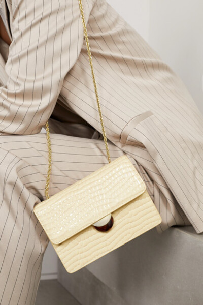 Loeffler Randall 这款 “Amina” 米色单肩包可与各色衣装和谐互衬，包内空间又足够容纳随身必备物品，堪称百搭实用的日常包袋之选。它以仿鳄鱼纹漆皮制成，设有玳瑁纹树脂摁扣。不妨选戴珠宝，呼应亮泽的金色麻花编…