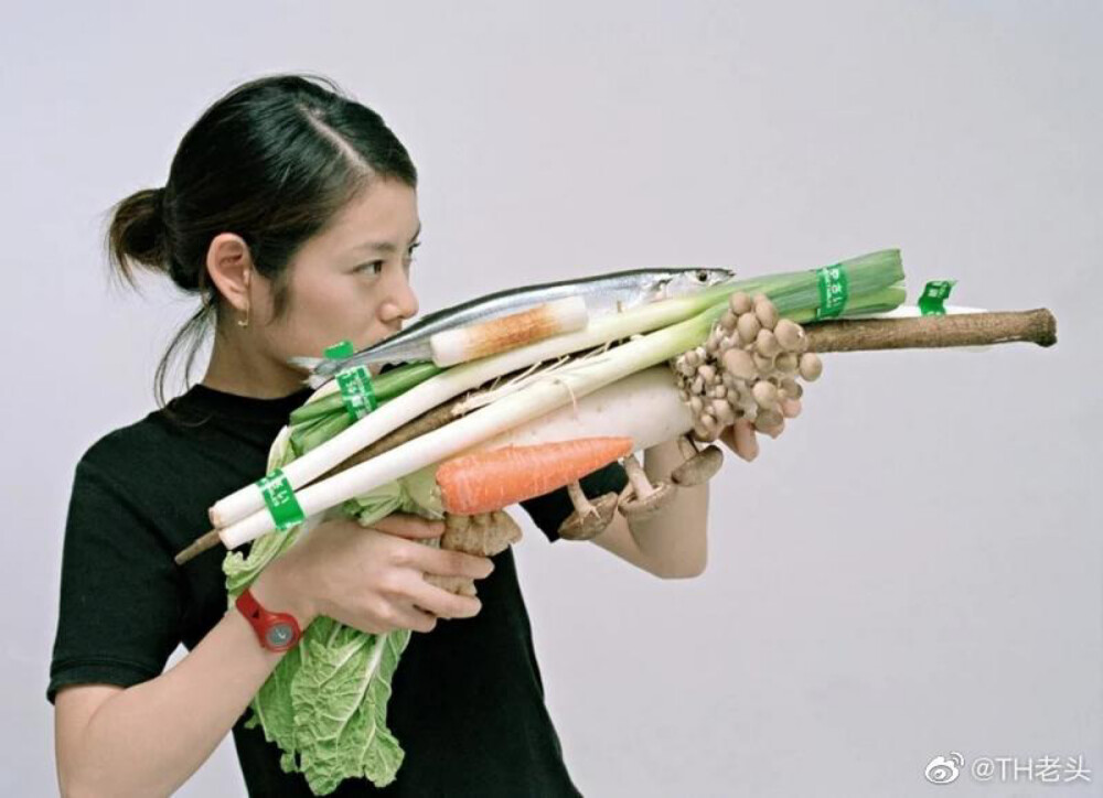 这是日本摄影师小沢刚的「Vegetable Weapon」系列作品，相中的女性手拿用蔬菜砌成的「机关枪」，做出坚定的眼神。摄影师表示，想将战争场景转变成有趣的互动方式，宣扬世界和平。照片由 2001 年起开始拍摄，地点包括亚洲、美洲、欧洲和非洲等地，参与拍摄的女性都是当地妇女。在拍照之后，「机关枪」就会还原成一棵棵蔬菜，煮好后大家一起享用。摄影师认为，这幽默的「裁军」过程可以促进沟通，甚至是作为不同饮食文化的简介，而最终目的就是鼓励观众反思战争的愚蠢，宣扬世界和平。