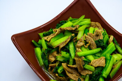 芹菜 蔬菜 植物 农作物 种植 低热量 膳食纤维 健康 瘦身 减肥 有机食品 绿色食品 绿叶菜 青菜 食品 食物 食材 肉 炒菜 热的 熟的 家常菜 传统菜 中国菜 营养丰富 膳食均衡 白色背景 棕瓷盘
