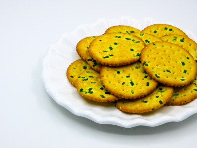 葱油饼干 葱 葱花 大葱 食用油 植物油 饼干 蛋 鸡蛋 卵 小麦 白面 蒸 熟的 甜点 糕点 点心 面点 蜂蜜 甜蜜 分享 烤 烘焙 食物 食品 美食 美味 膳食 饮食 白色瓷盘 容器 瓷盘 圆形 装饰 白色 白色背景 吃 中国传统糕…