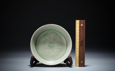 宋·龙泉窑青釉洗
【规格】口径13.3cm，高3.5cm，底径3.9cm
【品相】盘心一处小磕，口沿轻微剥釉，底足轻微失肉
此件宋·龙泉窑青釉洗，敞口，浅腹，平足，底足露胎。造型端状，简洁明了。水洗内外皆施青釉，施釉均匀…