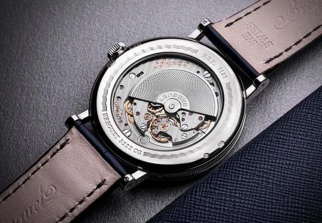 宝玑（BREGUET）2020经典系列7137腕表（18K白金表壳）（表底）
以篮织纹标示动力储备显示区域、以棋盘纹呈现日期显示并以巴黎钉纹装饰表盘的主要部分。白色金款的表盘呈宝玑蓝色，玫瑰金款的表盘颜色则由银粉配合软刷打造而成。
7137参数：18K白金或玫瑰金表壳，带有钱币纹装饰，圆形焊接式表耳，以螺丝栓固定。直径39毫米，厚度8.65毫米，防水深度30米。
7137新款搭载502.3 QSE1机芯，硅质平游丝，镌刻独立编号与宝玑签名。18K金质摆陀饰有手工玑镂刻花装饰。