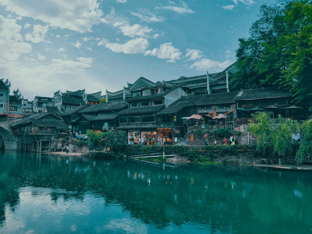 凤凰，北门古城楼、石板老街、风雨桥、沱江两岸的吊脚楼是这座城市的历史印记，清澈的沱江水缓缓从古城中间穿过，踏着石墩从沱江上走过，感受清凉一夏；夜晚，寻一处临江酒吧，看着两岸灯光倒映在江面，听着歌，喝着酒，慢慢欣赏这美丽的夜景！