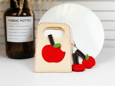 ¨̮ ᴴᴬᵛᴱ ᴬ ᴳᴼᴼᴰ ᵀᴵᴹᴱ
可爱的小苹果，可以用于收纳数据线、充电线和耳机线，充电时可以把手机放在包里，手提处挂在充电器上，简单好看又实用。
材料：不织布 、刺绣线、链条
工具：绣针、剪刀