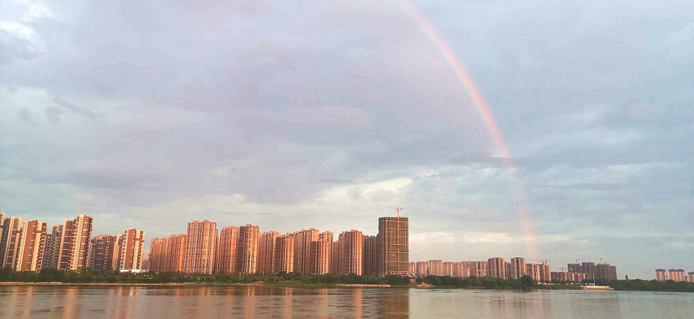 6月25傍晚时分，一场雨过后，江西吉安城区上空突然出现一道壮丽大彩虹，彩虹与空中的云彩、与高楼建筑、吉安大桥、赣江交相辉映，构成一幅美丽的风光大片。这一奇特的自然现象，吸引了许多市民驻足观望，并把这罕见的美景拍摄下来。（摄/肖勇）