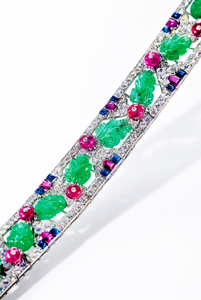 Tutti Frutti 手链，by Cartier，约1930年
镶嵌雕纹祖母绿、红宝石圆珠、弧面切割蓝宝石、弧面切割红宝石，旧式切割和单式切割钻石，底座由铂金制作。